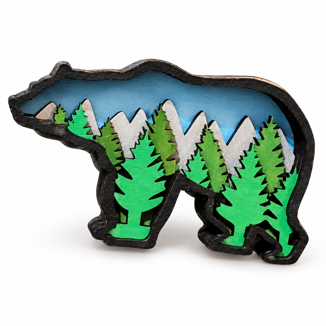 Laser-cut layered wood magnet with a forest and mountain scene